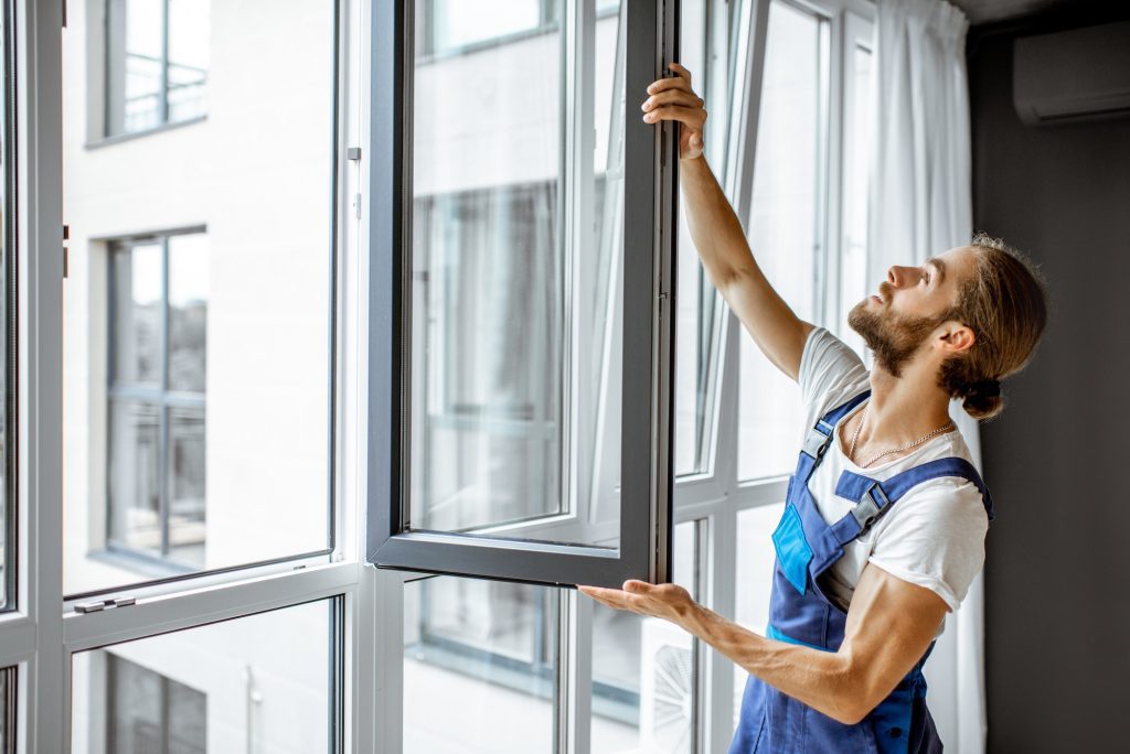 Workman adjusting window frames at home